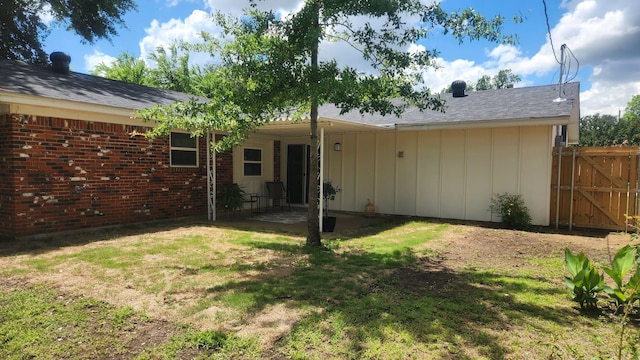 1709 Pamela Ln, Fort Worth, TX 76112 - back of house with board and batten siding, a patio area, brick siding, and a gate