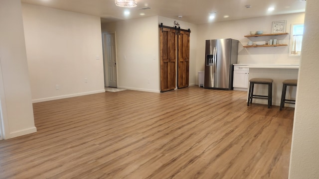 1709 Pamela Ln, Fort Worth, TX 76112 - living area with a barn door, light wood-type flooring, baseboards, and recessed lighting