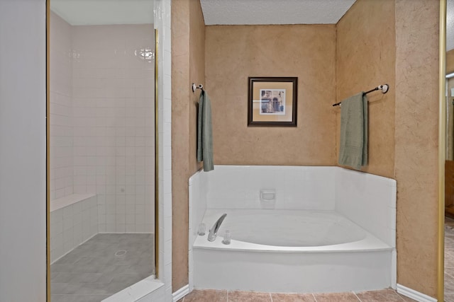bathroom featuring a garden tub, tiled shower, and tile patterned flooring