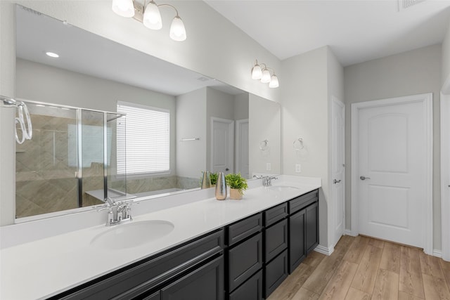 3117 Moldboard Dr, Mckinney, TX 75071 - bathroom with a shower stall, wood finished floors, double vanity, a bathtub, and baseboards