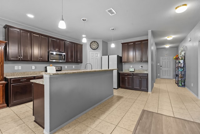 2304 Bermont Red Ln, Fort Worth, TX 76131 - kitchen with stainless steel appliances, light tile patterned flooring, hanging light fixtures, and dark brown cabinets