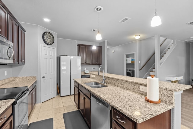 2304 Bermont Red Ln, Fort Worth, TX 76131 - kitchen featuring a sink, appliances with stainless steel finishes, a center island with sink, decorative light fixtures, and light stone counters