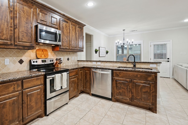 kitchen with appliances with stainless steel finishes, a sink, a chandelier, light tile patterned floors, and crown molding