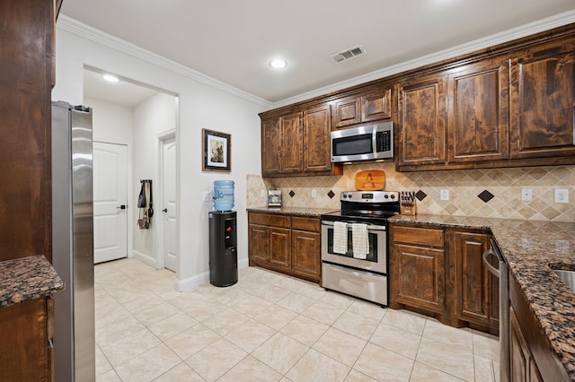kitchen featuring appliances with stainless steel finishes, light tile patterned floors, ornamental molding, backsplash, and dark brown cabinets
