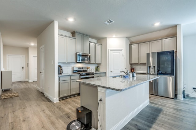 7332 Carnation St, Little Elm, TX 76227 - kitchen with appliances with stainless steel finishes, a sink, gray cabinets, light wood-type flooring, and recessed lighting