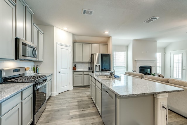 7332 Carnation St, Little Elm, TX 76227 - kitchen with appliances with stainless steel finishes, gray cabinetry, a sink, open floor plan, and recessed lighting