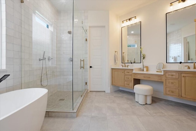 bathroom with a stall shower, tile patterned floors, a freestanding bath, and double vanity