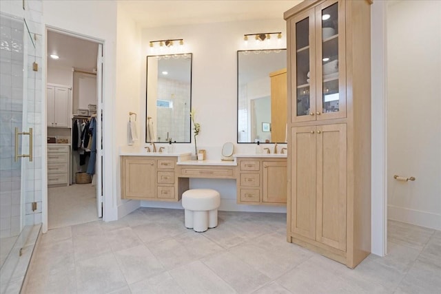 bathroom featuring a shower stall, a spacious closet, double vanity, and tile patterned floors