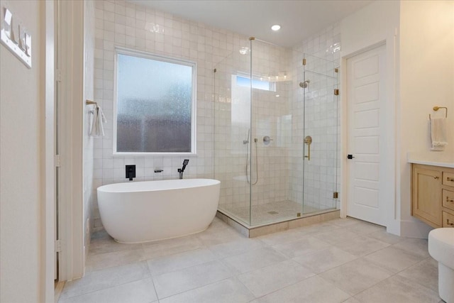bathroom featuring a stall shower, tile patterned flooring, a soaking tub, vanity, and recessed lighting