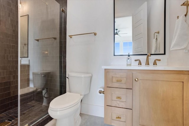 bathroom with toilet, a stall shower, ceiling fan, and vanity