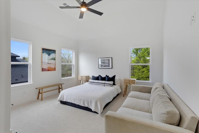 carpeted bedroom featuring multiple windows and ceiling fan