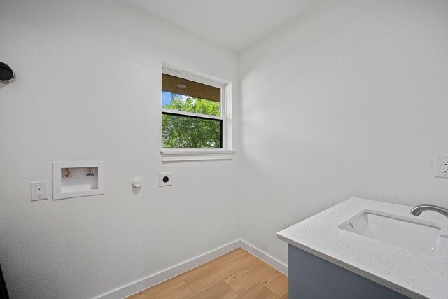 1500 W Virginia St, Mckinney, TX 75069 - laundry area with hookup for an electric dryer, baseboards, light wood-style flooring, and hookup for a washing machine