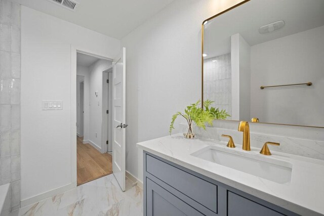 1500 W Virginia St, Mckinney, TX 75069 - bathroom with baseboards, vanity, and marble finish flooring