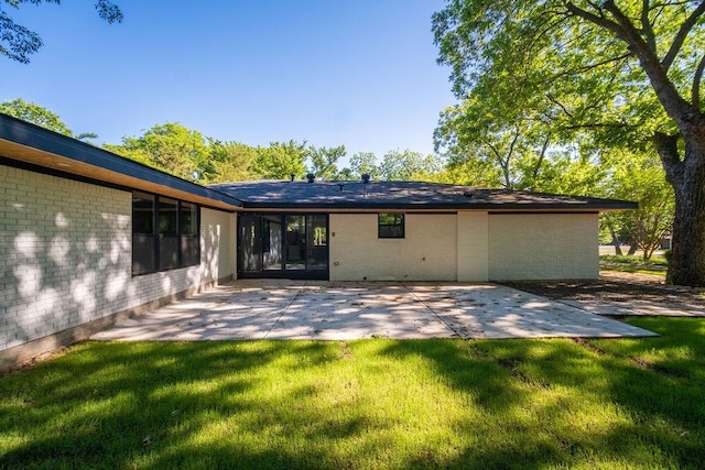 1500 W Virginia St, Mckinney, TX 75069 - rear view of property featuring a patio, brick siding, and a lawn