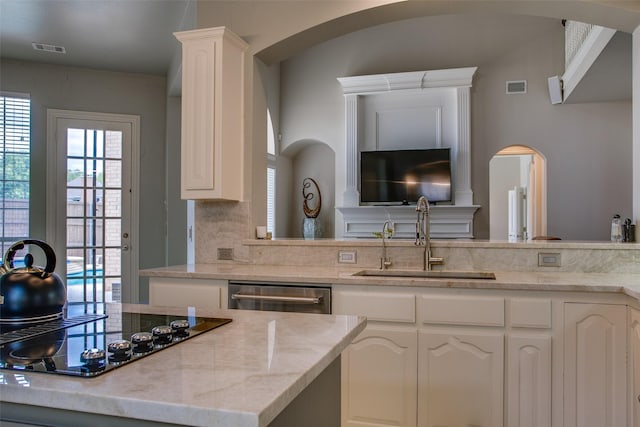 6513 Crawley Dr, Plano, TX 75093 - kitchen with a sink, black electric cooktop, arched walkways, dishwasher, and white cabinetry