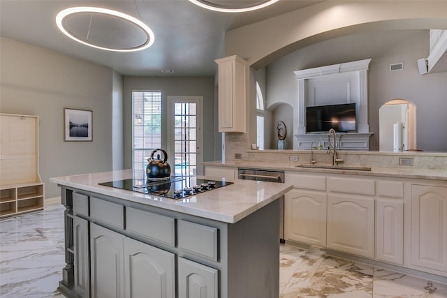 6513 Crawley Dr, Plano, TX 75093 - kitchen featuring a sink, light marble finish floors, black electric cooktop, arched walkways, and a kitchen island