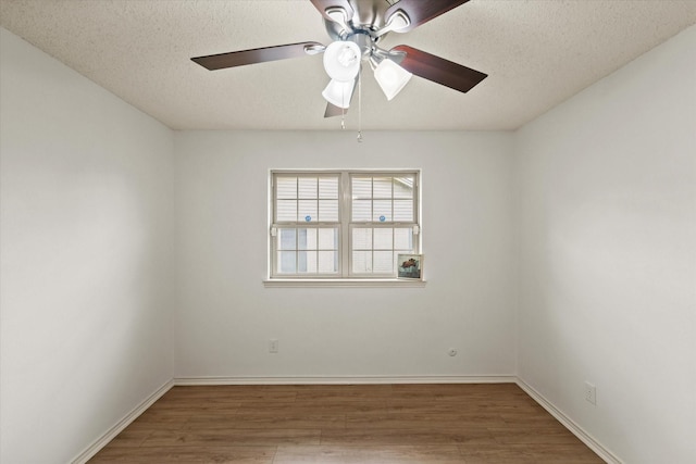 spare room featuring wood finished floors, a textured ceiling, a ceiling fan, and baseboards