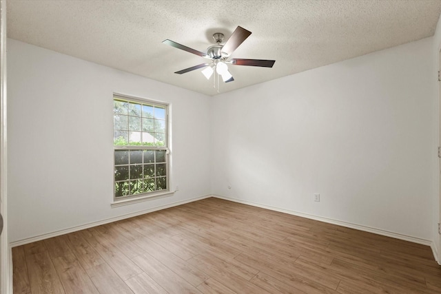 empty room featuring wood finished floors, ceiling fan, a textured ceiling, and baseboards
