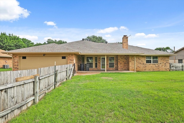 back of property with central air condition unit, a garage, brick siding, a chimney, and a patio area