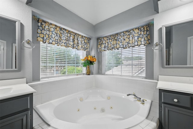 bathroom with vanity, a tub with jets, and lofted ceiling