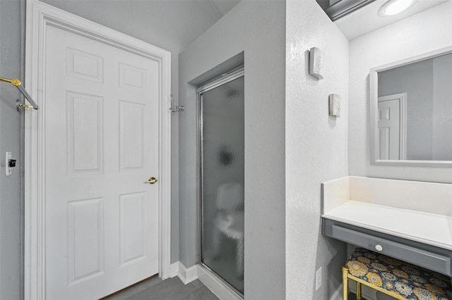 bathroom featuring a stall shower, baseboards, and tile patterned floors