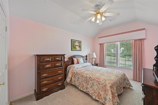 bedroom with lofted ceiling, light colored carpet, baseboards, and a ceiling fan