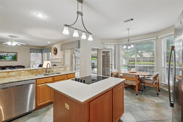 kitchen featuring dishwasher, black electric stovetop, a sink, light countertops, and a kitchen island