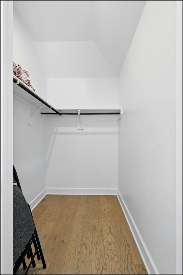 8529 Melrose, The Colony, TX 75056 - walk in closet featuring wood finished floors and lofted ceiling
