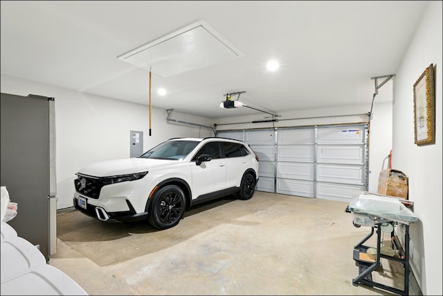 8529 Melrose, The Colony, TX 75056 - garage featuring electric panel, a garage door opener, freestanding refrigerator, and recessed lighting