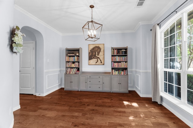 700 Renault Way, Mckinney, TX 75071 - dining space featuring a chandelier, crown molding, arched walkways, dark wood finished floors, and wainscoting