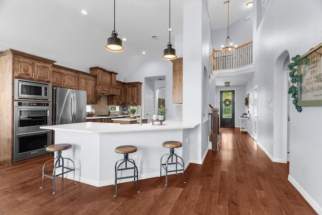 700 Renault Way, Mckinney, TX 75071 - kitchen with stainless steel appliances, high vaulted ceiling, arched walkways, a kitchen bar, and light countertops
