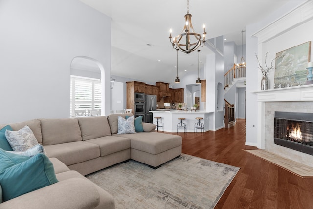 700 Renault Way, Mckinney, TX 75071 - living area featuring a chandelier, stairway, wood finished floors, a high ceiling, and a tiled fireplace