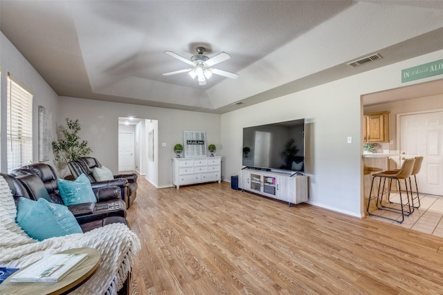4942 US Highway 69, Denison, TX 75021 - living room featuring a tray ceiling, ceiling fan, light wood finished floors, and baseboards