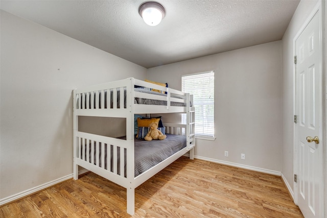 4942 US Highway 69, Denison, TX 75021 - bedroom with wood finished floors, baseboards, and a textured ceiling