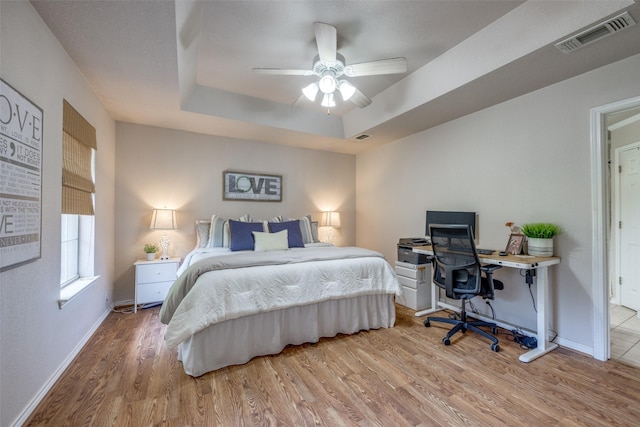 4942 US Highway 69, Denison, TX 75021 - bedroom featuring wood finished floors, baseboards, a tray ceiling, and ceiling fan