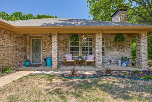 4942 US Highway 69, Denison, TX 75021 - entrance to property featuring a chimney, brick siding, and a shingled roof