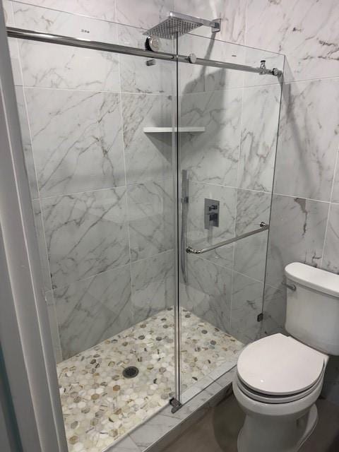 full bathroom featuring toilet and a shower stall