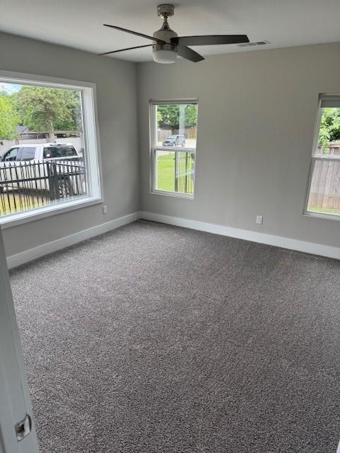 unfurnished room with a ceiling fan, baseboards, and carpet floors