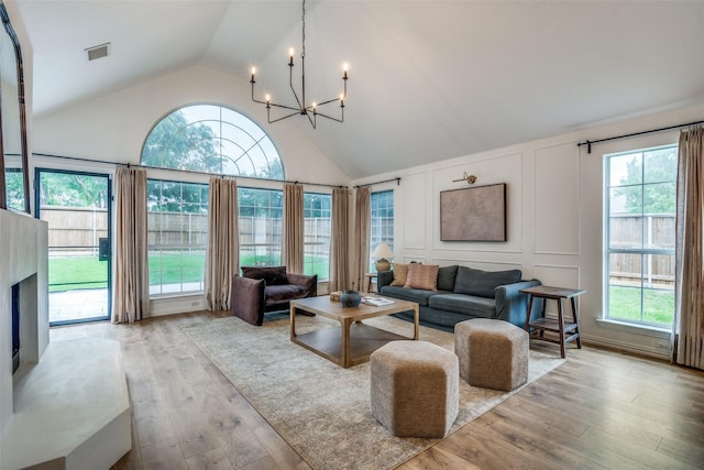 6520 Creek Crossing Ln, Sachse, TX 75048 - living area featuring a decorative wall, a chandelier, wood-type flooring, and high vaulted ceiling