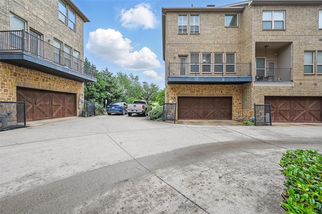 view of property exterior with brick siding, an attached garage, and a balcony