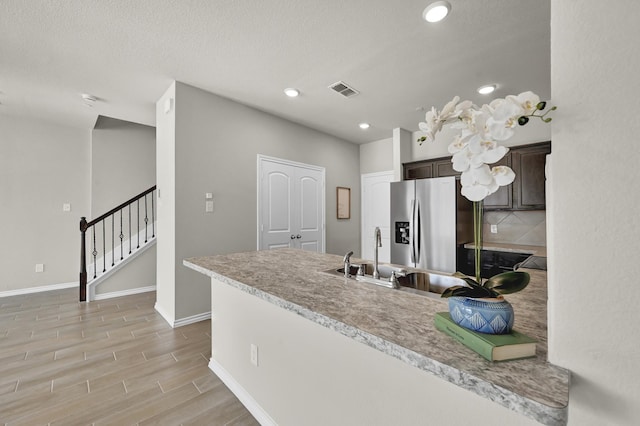 2867 Baneberry Ln, Mesquite, TX 75150 - kitchen with stainless steel fridge with ice dispenser, dark brown cabinets, a sink, light countertops, and baseboards