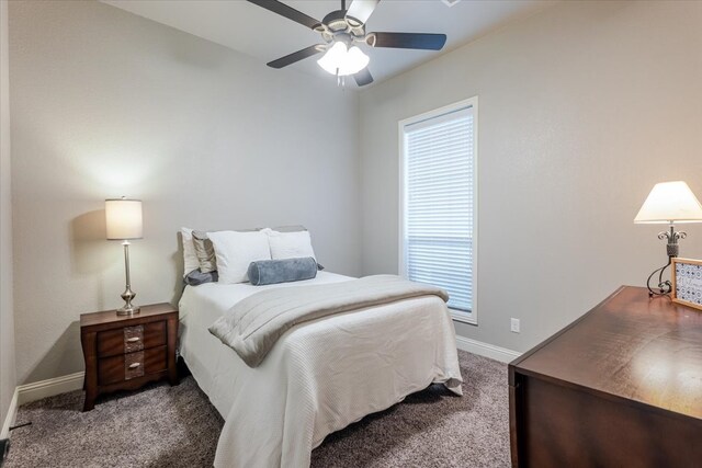 carpeted bedroom featuring baseboards and a ceiling fan