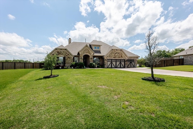 view of front of home with stone siding, a chimney, an attached garage, and driveway