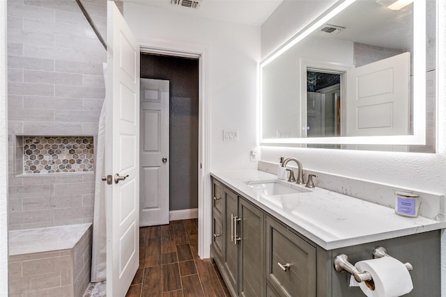 2802 Rio Grande Pass, Mesquite, TX 75150 - bathroom with vanity, tiled shower, wood finish floors, and baseboards