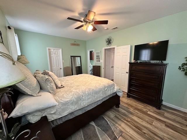 bedroom featuring wood finished floors, baseboards, and ceiling fan