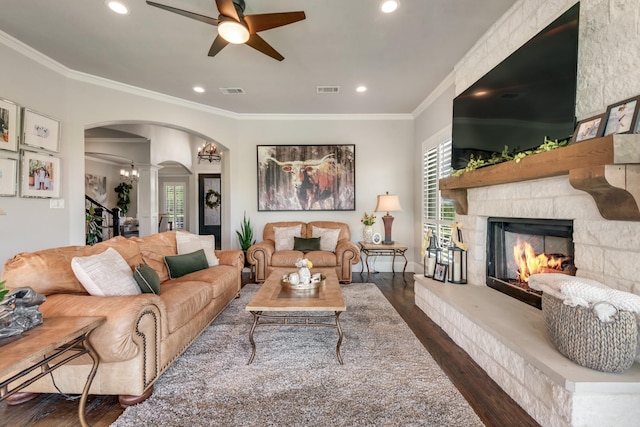 5 Maltese Cir, Heath, TX 75032 - living room featuring arched walkways, wood finished floors, a ceiling fan, a stone fireplace, and ornate columns