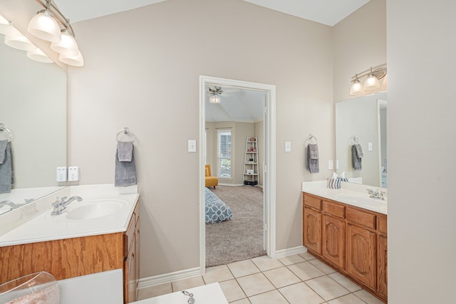 full bathroom featuring two vanities, tile patterned floors, ceiling fan, baseboards, and lofted ceiling