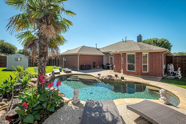 view of pool featuring a fenced backyard, a storage unit, a patio, and an outdoor structure
