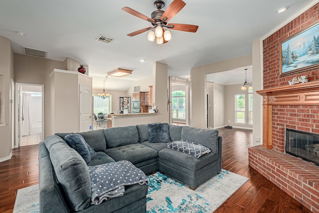 living area featuring dark wood-style floors, a fireplace, baseboards, and a ceiling fan