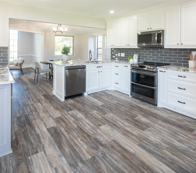 102 Camino Real W, Wylie, TX 75098 - kitchen featuring stainless steel appliances, a sink, a peninsula, white cabinets, and recessed lighting